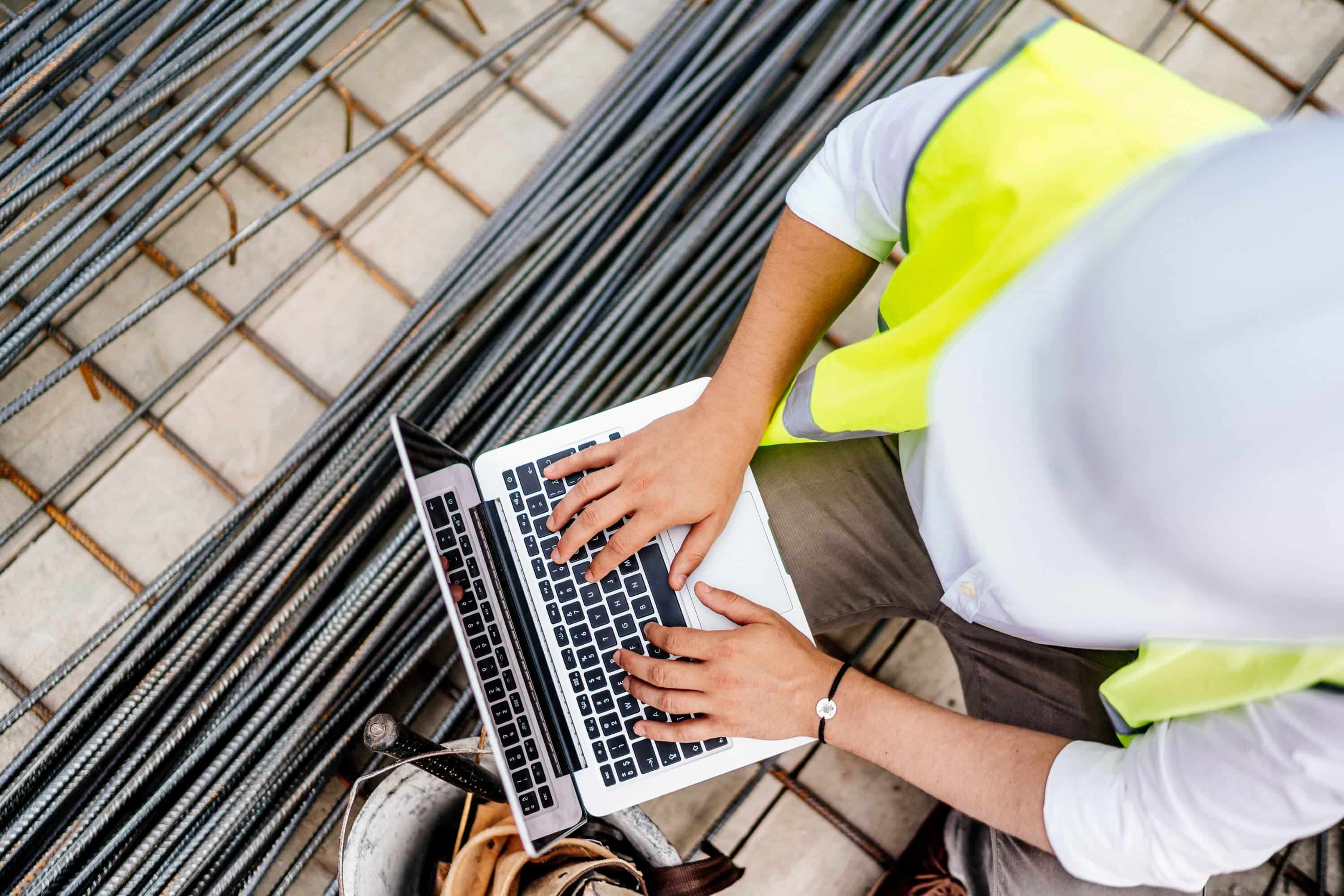 Construction worker checking email on laptop