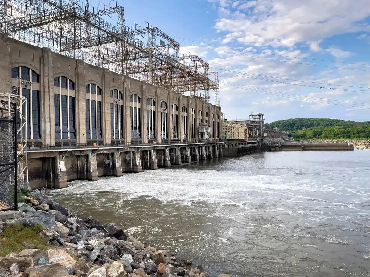 The Conowingo Dam is a massive concrete structure stretching across the wide Susquehanna River, with towering walls and a broad spillway that controls the river’s flow.