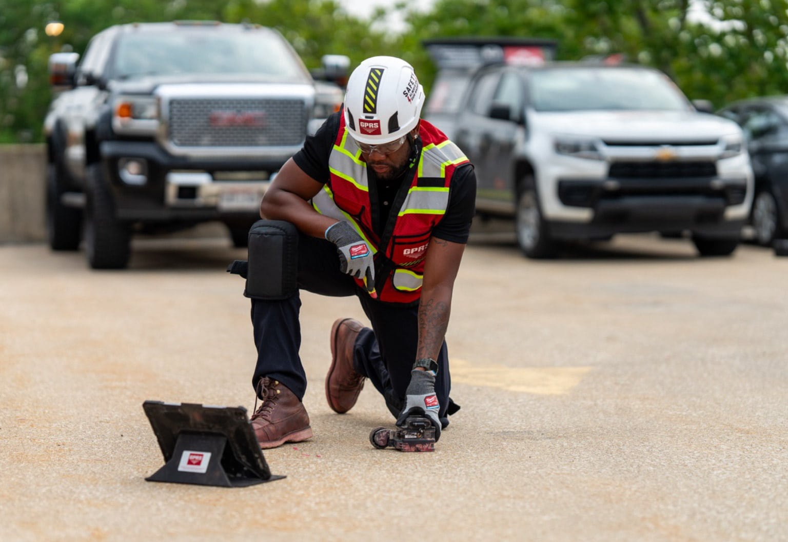 A GPRS Project Manager using a ground penetrating radar scanner on the surface of a parking garage.