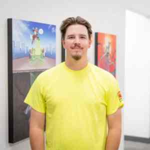 GPRS Project Manager Nate Simmons poses for a photo in a yellow safety tee shirt in the GPRS corporate offices in Maumee, Ohio.