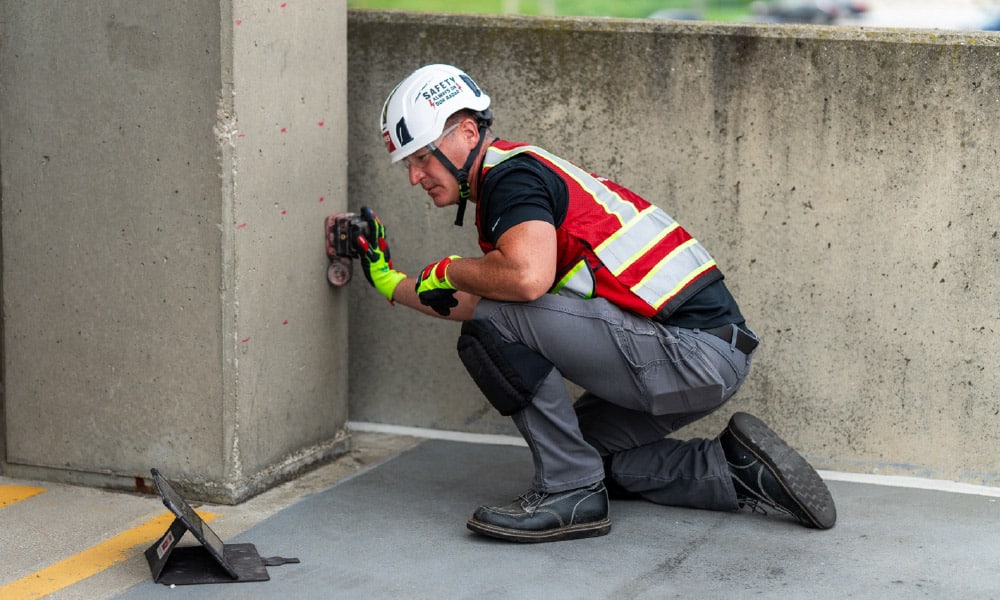 A GPRS Project Manager puts a ground penetrating radar concrete scanner on the concrete pillar of a parking garage.