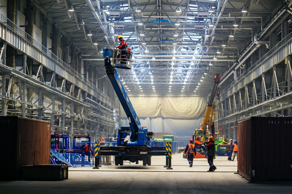 Construction work inside a warehouse space.