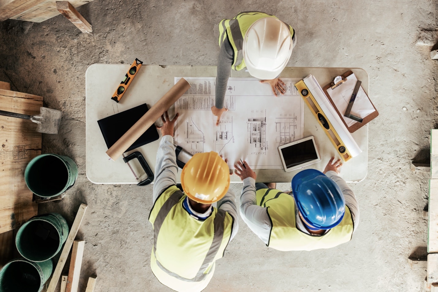 Top-down view of construction workers reviewing existing conditions documents.