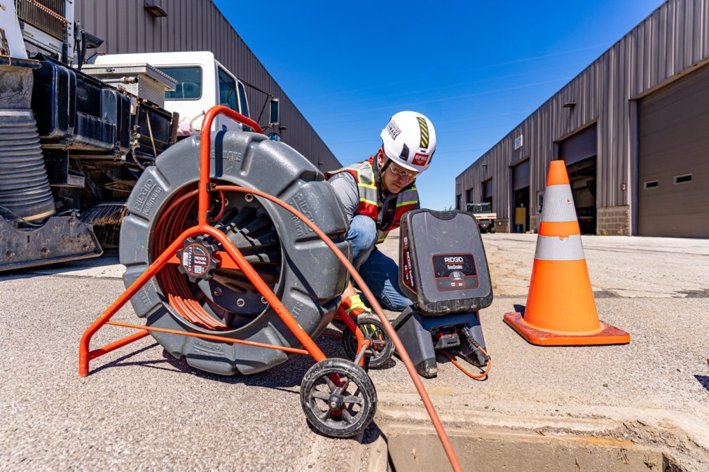 A GPRS Project Manager looks at a monitor attached to a push-fed sewer scope.