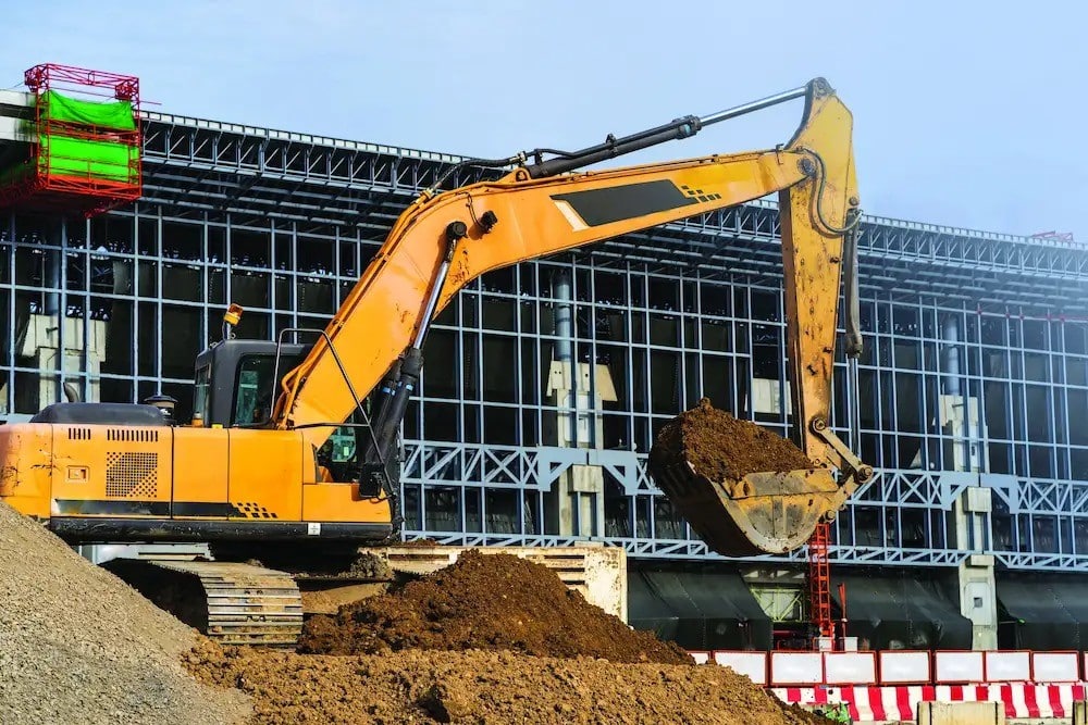 An excavator digging a hole on a construction site.