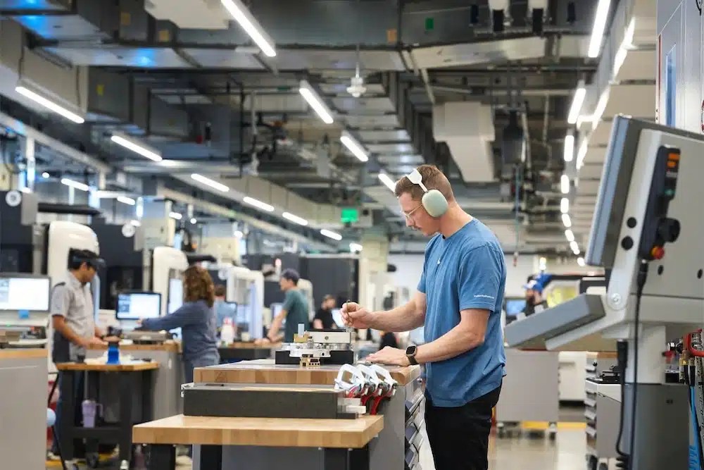 A person wearing headphones working in a manufacturing facility.
