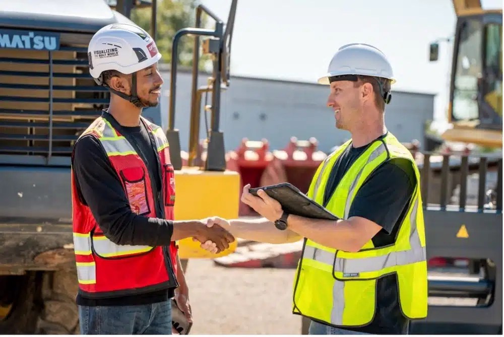 GPRS Project Manager shaking hands with a contractor on a construction site.