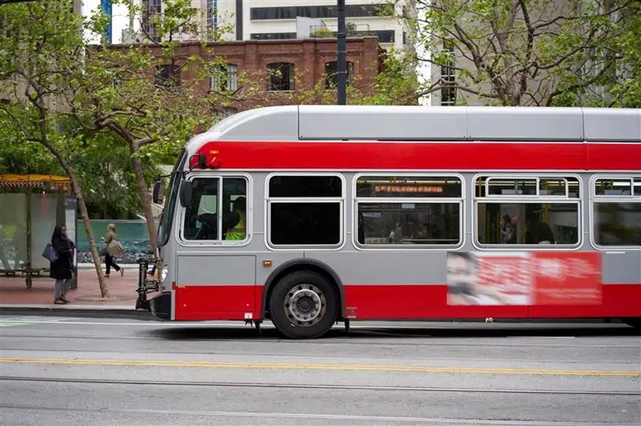 A red and grey bus on a city street.
