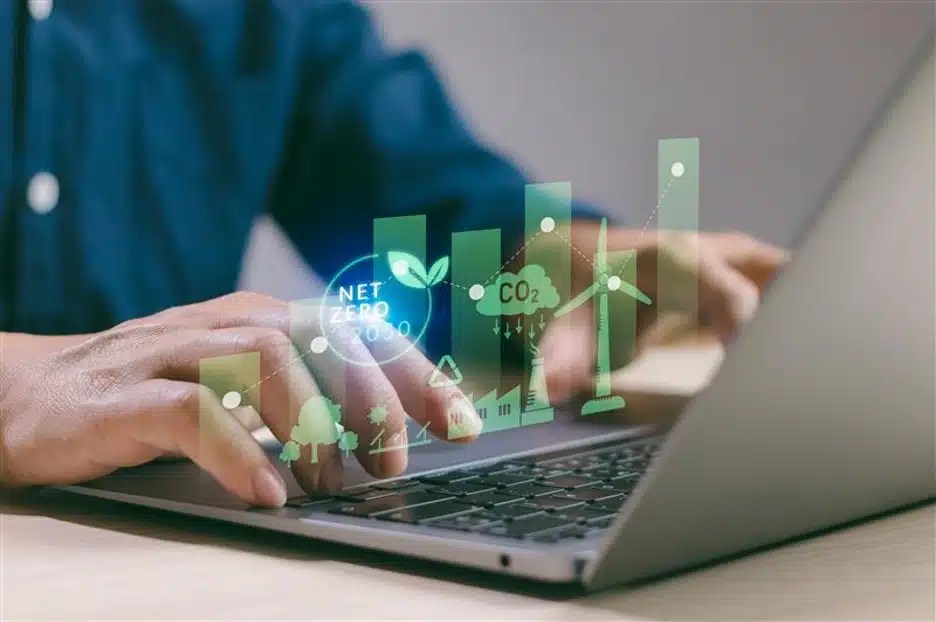 A computer-generated graphic of net zero practices is superimposed over a person’s hands on the keyboard of a laptop.